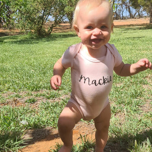 Mackie is adventuring outside in her personalised name onesie in our light pink with her name printed in black font 7.